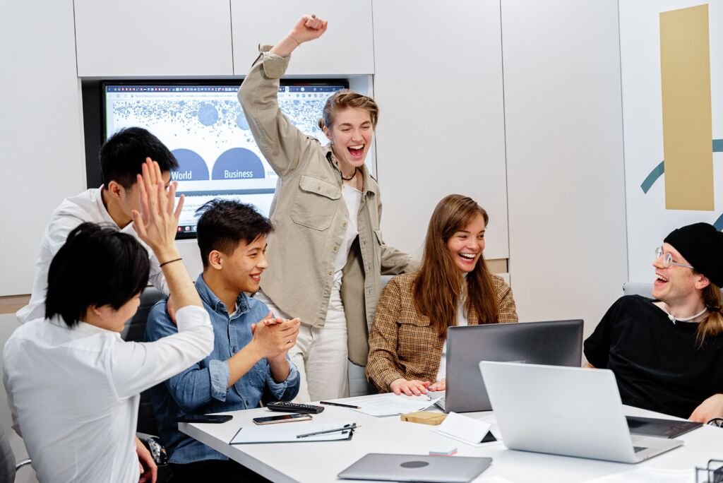 Diverse team celebrating success during a business meeting with a support services partner