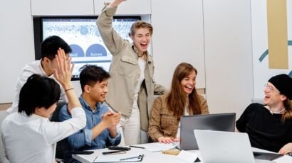 Diverse team celebrating success during a business meeting with a support services partner