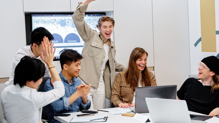 Diverse team celebrating success during a business meeting with a support services partner